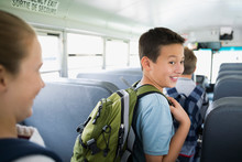 Smiling Schoolboy With Backpack In Aisle School Bus