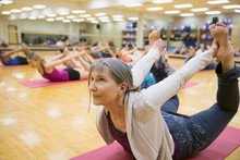 Group Practicing Bow Pose In Yoga Class