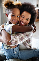 portrait of a joyful mother and her daughter smiling and hugging