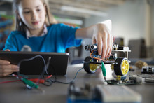 Pre-adolescent Girl Programming Robotics At Digital Tablet In Classroom