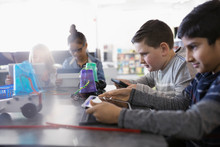 Pre-adolescent Boys Programming Robotics At Digital Tablets In Classroom