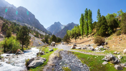 Wall Mural - Scenic  panorama of sunny day on hiking track around among Fann mountains, Tajikistan. Stormy river runs down from of slope mountains.