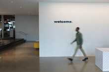Businessman Walking Past Welcome Sign In Office Lobby