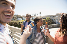Couples Laughing And Eating Ice Cream Cones On Sunny California Bridge