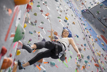 Smiling Woman Climbing Indoor Rock Wall