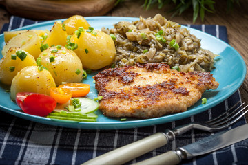 Wall Mural - Fried pork chop, baked potatoes and fried young cabbage.