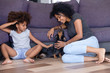 Happy black mom and daughter relax having fun with dog
