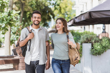 Wall Mural - Beautiful happy couple summer portrait. Young joyful smiling woman and man in a city. Love, travel, tourism, students concept	