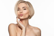 Young beautiful blond european woman sending kiss with pout perfect lips to camera.