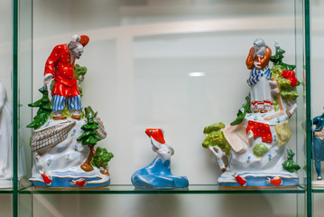 Wall Mural - Rare porcelain figurines on a glass shelf. The Tale of the Fisherman and the Fish