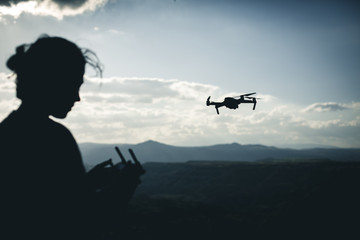 Operador de drone volando en la naturaleza cerca de las montañas