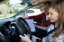 Father With Driving Manual Teaching Tween Daughter How To Drive Car
