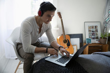 Young Woman Listening To Music With Headphones At Laptop