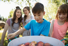 Kids Bobbing For Apples At Summer Neighborhood Block Party