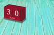 © DiegoAransay - June 30th, Day 30 of June month, Red calendar on workplace green wood, Empty space for text, Copy space right