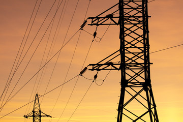 Electric pole with wires on a sunset background