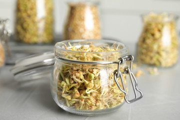 Sticker - Glass jar of sprouted green buckwheat on light grey table