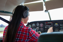 Female Pilot Flying Airplane In Airplane Cockpit
