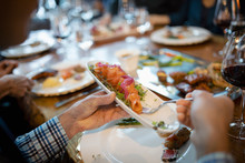 Close Up Man Eating Salmon Tapas, Dining At Restaurant Table