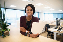 Portrait Confident Businesswoman With Paperwork In Office