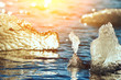 Sparkling pieces of ice in ocean water and sunny bokeh.