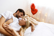 Love. Valentine's Day. . Emotions. Young Couple Are Looking At Each Other And Laughing While Lying Together On The Bed