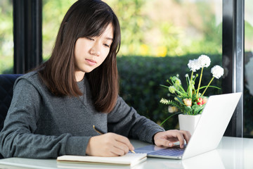 Teenage student using laptop doing homework at home