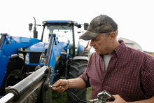 Male Farmer Fixing Tractor