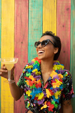 Portrait Carefree, Playful Young Woman Wearing Leis And Drinking Margarita On Summer Patio