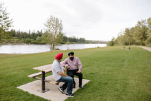 Mature Indian Men On Park Bench Talking