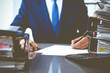 © rogerphoto - Bookkeeper or financial inspector and secretary making report, calculating or checking balance. Internal Revenue Service inspector checking financial document. Audit concept