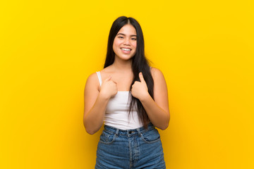 Wall Mural - Young teenager Asian girl over isolated yellow background with surprise facial expression