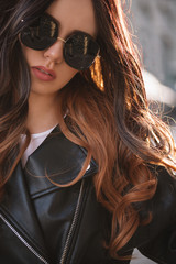 Wall Mural - Beautiful brunette woman in black sunglasses in outdoor.