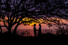 Silhouettes Of Embracing Couple At Sunset