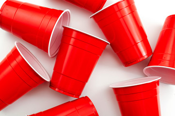 College party and beer pong concept with red drinking plastic cups on white background