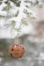 Bell Ornament Hanging From Snowy Tree Branch