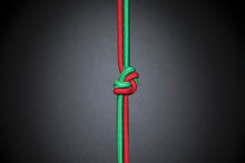 Red And Green Rope Knotted In Teamwork, Unity