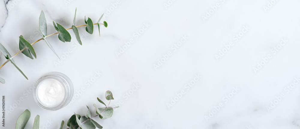 Natural organic cream jar with eucalyptus leaves on marble background. Flat lay, top view, copy space. Natural organic product, beauty and spa concept - obrazy, fototapety, plakaty 