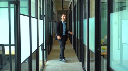 Canvas Print - Handsome businessman celebrating his success by dancing in the office corridor. Shot in 4k resolution