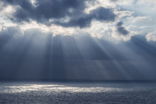 Sun Rays Through The Clouds Over The Sea