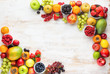 Rainbow fruits background, strawberries raspberries oranges plums apples kiwis grapes blueberries mango persimmon on white wooden table, top view, copy space for text, selective focus