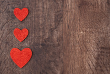 Three Red Glitter Hearts On A Rustic Wood Table As A Background