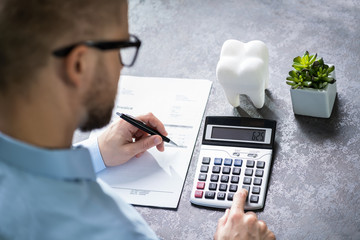 White Tooth In Front Of Man Calculating Bill