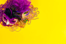Festive Carnival Masks And Beads On Yellow Background.