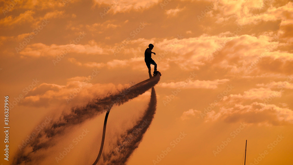 Person propelling through air on flyboard - obrazy, fototapety, plakaty 
