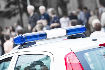 Police car with blue lights on the crime scene in traffic / urban environment.