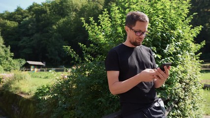 man is using smartphone outdoors in garden