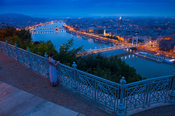 Wall Mural - woman in Budapest city. evening scene with panorama of Danube river. Hungary