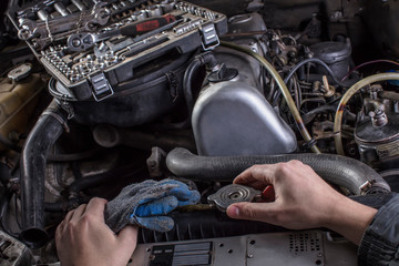 Car engine repair. Engine cooling system services. Hands with a mechanic with a wrench repair Mercedes parts.