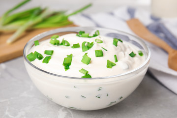 Fresh sour cream with onion on grey marble table, closeup